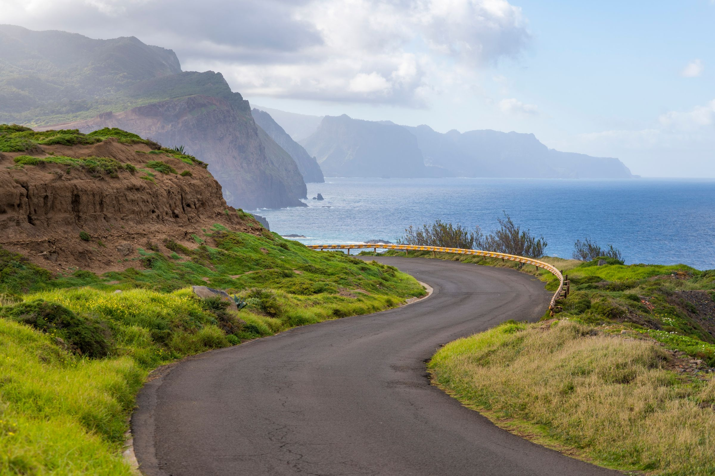 Small rental car on a winding coastal road in Madeira